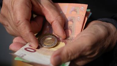Seniorin hält Geld in Händen