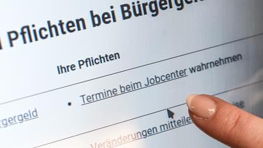Ein Finger zeigt auf einem Bildschirm im Jobcenter Friedrichshain-Kreuzberg auf den Punkt «Termine beim Jobcenter wahrnehmen», der auf einer Internetseite der Bundesagentur für Arbeit unter der Überschrift «Pflichten bei Bürgergeld» aufgeführt ist. In Sachsen-Anhalt haben die Jobcenter im vergangenen Jahr mehr Kürzungen beim Bürgergeld ausgesprochen als im Vorjahr.