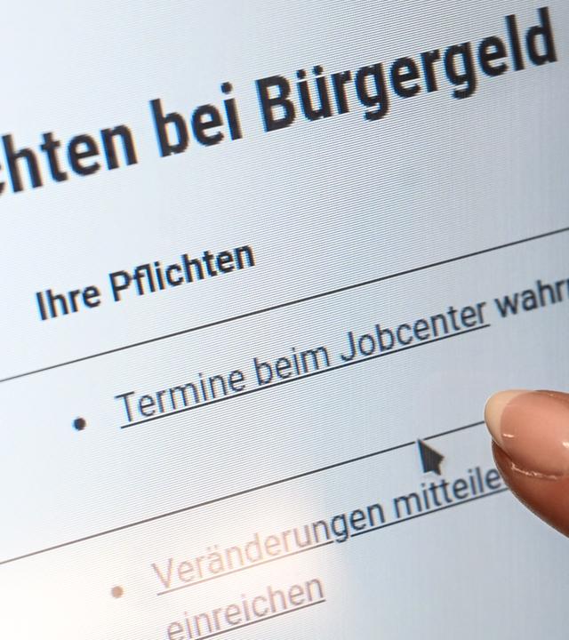 Ein Finger zeigt auf einem Bildschirm im Jobcenter Friedrichshain-Kreuzberg auf den Punkt «Termine beim Jobcenter wahrnehmen», der auf einer Internetseite der Bundesagentur für Arbeit unter der Überschrift «Pflichten bei Bürgergeld» aufgeführt ist. In Sachsen-Anhalt haben die Jobcenter im vergangenen Jahr mehr Kürzungen beim Bürgergeld ausgesprochen als im Vorjahr.