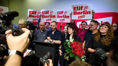 25.09.2026, Berlin: Elif Eralp (Mitte r), Fraktionsvorsitzende der Partei Die Linke im Berliner Abgeordnetenhaus, steht während eines Landesparteitags der Berliner Linken mit einem Blumenstrauß auf dem Podium. Auf dem Parteitag soll darüber abgestimmt werden, ob die Linke die Grünen und die SPD nach der Wahl zum Berliner Abgeordnetenhaus zu Sondierungsgesprächen einlädt.