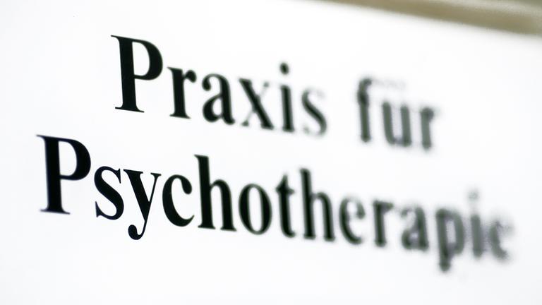 Ein Schild weist auf eine Praxis für Psychotherapie hin.