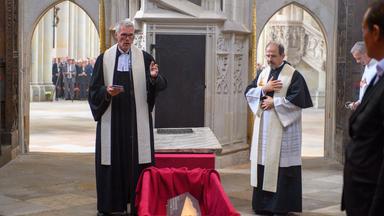 Feierliche Wiederbeisetzung von Kaiser Otto dem Großen. 01.09.2026, Sachsen-Anhalt, Magdeburg: Domprediger Jörg Uhle Wettler (l) und Domkapitular Matthias Haman (l) beten im Hohen Chor vom Dom an der Grablege von Kaiser Otto dem Großen. Dessen neuer Sarg ist im Sarkophag zu sehen. Im Dom fand die feierliche Wiederbeisetzung des Kaisers statt. In den vergangenen Monaten wurde Ottos Grabmal saniert.