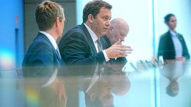 06.07.2026, Berlin: Lars Klingbeil (SPD, 2.v.l.), Bundesminister der Finanzen, und Steffen Meyer (l), Staatssekretär Haushalt im Bundesministerium der Finanzen, sprechen bei der Pressekonferenz zur Vorstellung des Planentwurfs für den Bundeshaushalt 2027 im Haus der Bundespressekonferenz neben Mathis Feldhoff, Vorsitzender der Bundespressekonferenz.