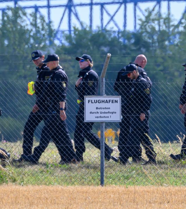 Einsatzkräfte der Polizei durchsuchen das Gelände abseits der Landebahn Nord auf dem Gelände des Flughafens Leipzig/Halle.