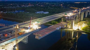 Das Mittelstück der neuen Rader Hochbrücke wird mit langsamer Geschwindigkeit eingehoben (Aufnahme mit Drohne). Am Abend und in der Nacht wird das 118 Meter lange und 1.250 Tonnen schwere Mittelstück der neuen Rader Hochbrücke über dem Nord-Ostsee-Kanal eingehoben.