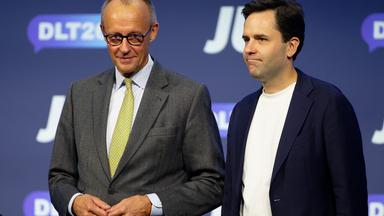 17.10.2026, Nordrhein-Westfalen, Bonn: Bundeskanzler Friedrich Merz (CDU, l) und Johannes Winkel (CDU), Vorsitzender der Jungen Union, stehen beim Deutschlandtag der Jungen Union auf der Bühne. 