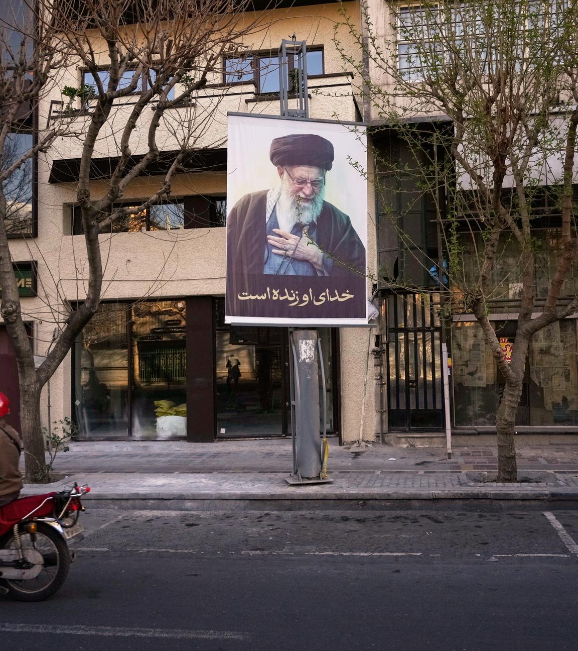 Ein Motorrad fährt an einem Bild des verstorbenen iranischen Obersten Führers Ajatollah Ali Chamenei auf einer leeren Straße vorbei, nachdem der Tod von Chamenei durch US-amerikanische und israelische Angriffe bestätigt wurde.