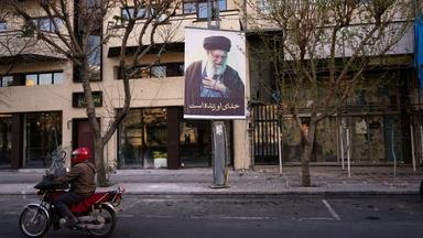 Ein Motorrad fährt an einem Bild des verstorbenen iranischen Obersten Führers Ajatollah Ali Chamenei auf einer leeren Straße vorbei, nachdem der Tod von Chamenei durch US-amerikanische und israelische Angriffe bestätigt wurde.