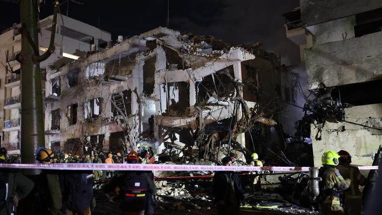 Israel, Tel Aviv: Israelische Ersthelfer treffen am Schadensort in Tel Aviv ein, nachdem iranische ballistische Raketen als Vergeltung für koordinierte US-amerikanisch-israelische Luftangriffe Teile der Stadt getroffen haben.