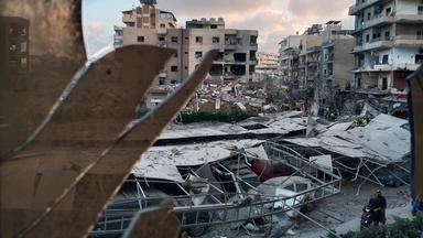 01.06.2026, Libanon, Tyros: Ein zerstörtes Gebäude, das bei einem israelischen Luftangriff getroffen wurde, ist durch ein zerbrochenes Fenster des Jabal-Amel-Krankenhauses zu sehen.