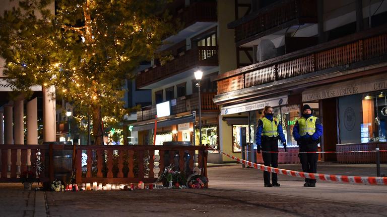 Kerzen und Blumen liegen an einer Absperrung zum Gedenken an die Opfer eines Brandes in einer Bar im Skigebiet Crans-Montana im Kanton Wallis, Schweiz.