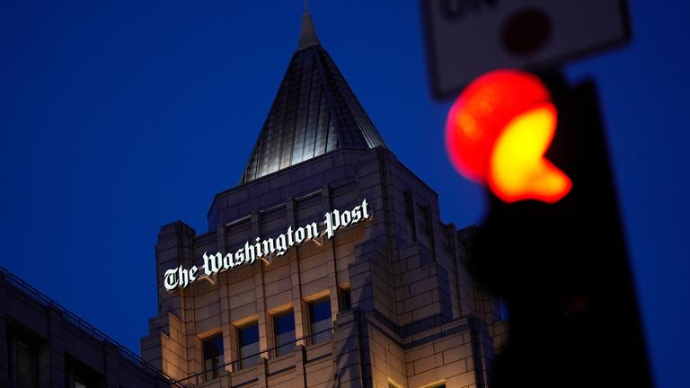 04.02.2026, USA, Washington: Eine rote Ampel leuchtet vor dem Gebäude One Franklin Square, Sitz der Zeitung «Washington Post» in der Innenstadt. 