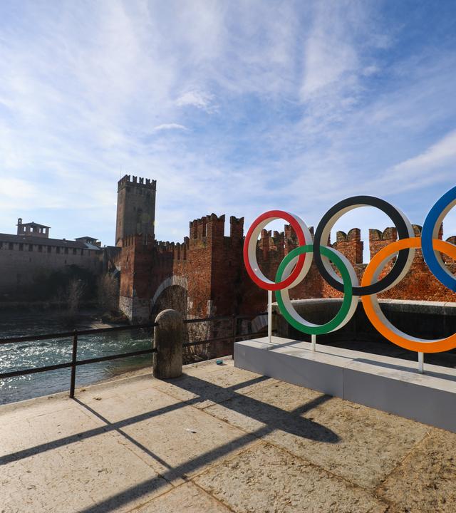 Italien, Verona: Die Stadt Verona zeigt olympischen Ringe an ihrem historischen Castelvecchio, da die Stadt eine wichtige olympische Stadt für die Winterspiele in Mailand Cortina 2026 wird. Verona wird die Schlussfeier der Olympischen Spiele und die Eröffnungsfeier der Paralympics in der antiken Arena di Verona ausrichten und das römische Amphitheater für diese Veranstaltungen im Februar und März 2026 in die "Verona Olympic Arena" verwandeln.