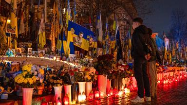 Menschen zünden auf dem Unabhängigkeitsplatz in Kiew Kerzen an, um dem vierten Jahrestag des russischen Einmarsches in die Ukraine zu gedenken.