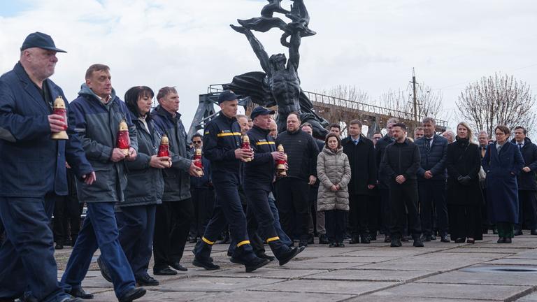 26.04.2026, Ukraine, Tschernobyl: Arbeiter und Retter nehmen an einer Gedenkfeier in der Allee der Liquidatoren teil, die vor 40 Jahren im Kernkraftwerk Tschernobyl ihr Leben verloren haben, Ukraine. Tschernobyl ist der ukrainische Name für die Stadt.