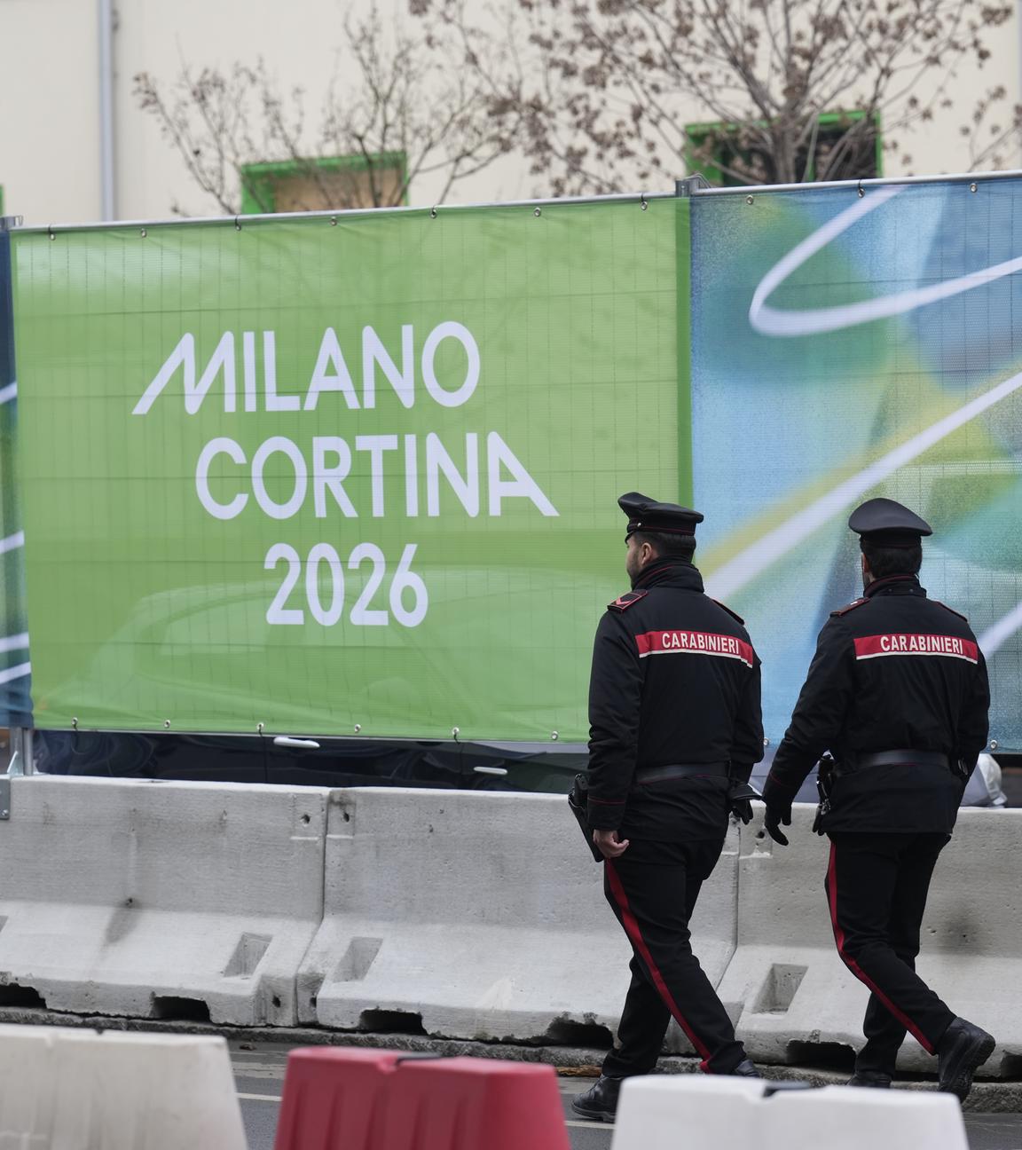 30.01.2026, Italien, Mailand: Polizisten gehen vor den Olympischen Winterspielen 2026 durch das Olympische Dorf.