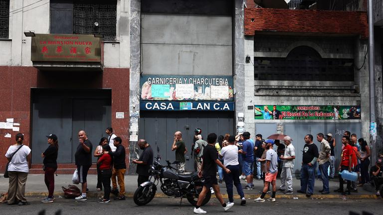 Menschen stehen vor einem Supermarkt in Caracas, Venezuela, am 3. Januar 2026 Schlange. US-Präsident Trump gab bekannt, dass US-Streitkräfte den venezolanischen Präsidenten Nicolas Maduro und seine Frau während einer Reihe groß angelegter Angriffe auf Caracas am 3. Januar 2026 erfolgreich gefangen genommen haben.