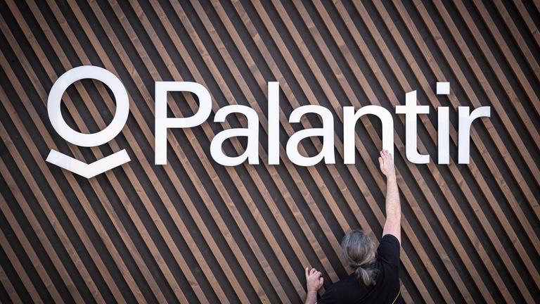 Arbeiter bringt das Palantir-Logo an