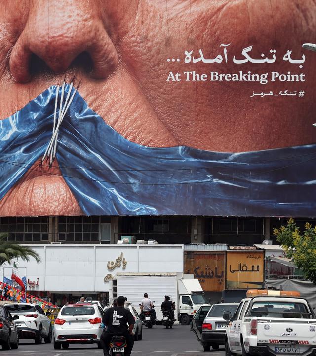 Iraner fahren am 28. Mai 2026 am Valiasr-Platz in Teheran, Iran, an einer großen Anti-US-Plakatwand vorbei, auf der US-Präsident Donald Trump und die Straße von Hormus zu sehen sind. US-Präsident Donald Trump gab kürzlich bekannt, dass ein mögliches Friedensabkommen zur Beendigung des Konflikts und zur Wiederöffnung der Straße von Hormus weitgehend durch pakistanische Vermittler ausgehandelt worden sei. Seitdem haben die USA jedoch neue Luftangriffe im Süden des Iran gestartet.
