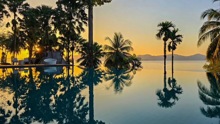 Schöner Blick auf den Sonnenuntergang von einem Infinity-Pool auf der Insel Koh Phayam in Thailand