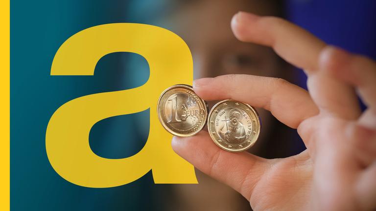 Ein Mädchen posiert in Sofia mit neuen Euro-Münzen mit bulgarischen Symbolen in der Hand.