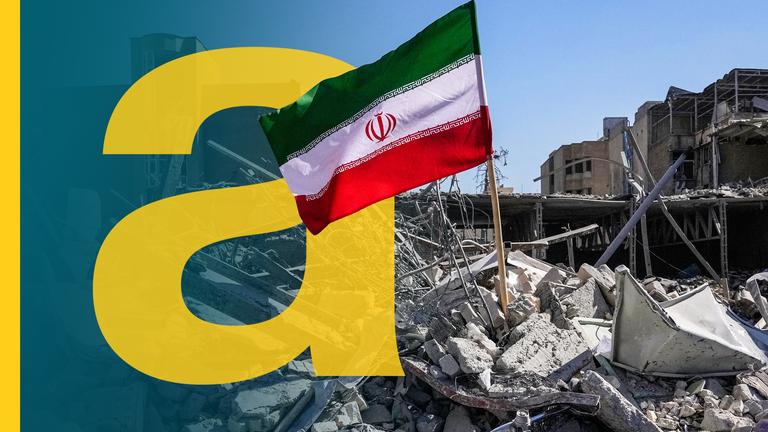 Die iranische Flagge steht auf den Trümmern eines zerstörten Gebäudes.