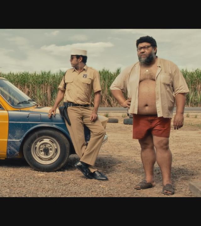 2 Männer stehen vor einem Polizeiauto in dem Film "The Secret Agent"