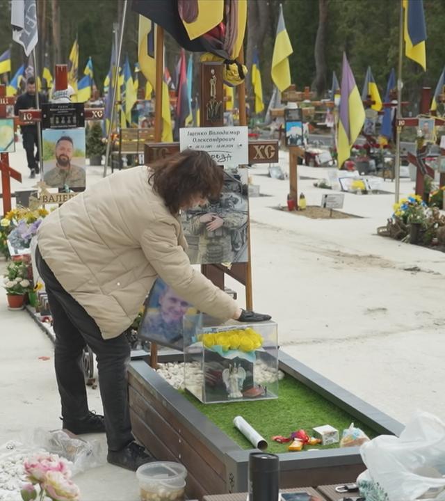 Ukrainische Frau auf einem Friedhof