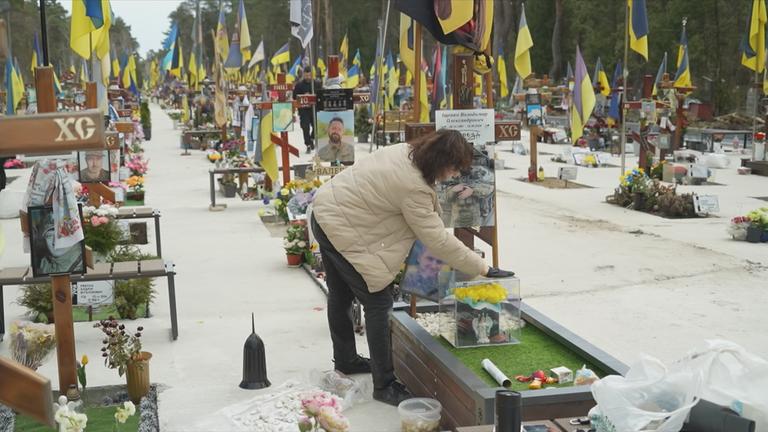Ukrainische Frau auf einem Friedhof