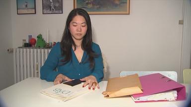 Frau  mit Unterlagen, sitzt am Tisch