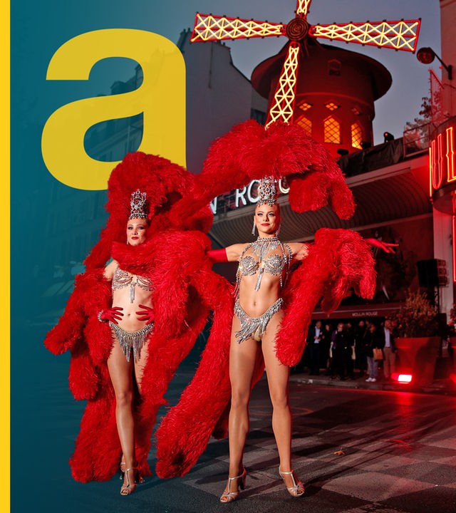 Leicht bekleidete Tänzerinnen stehen vor dem Moulin Rouge.