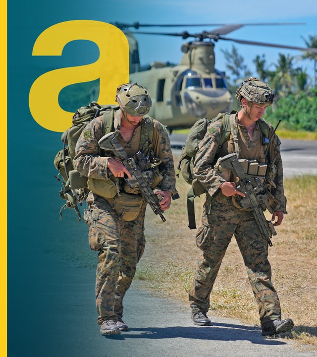 Zwei US-Soldaten vor Militärhubschraubern auf einem US-Stützpunkt.