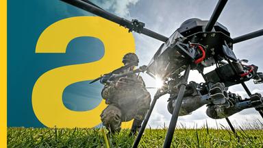 Ein Soldat hockt vor einer Drohne