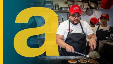 Ein Mitarbeiter eines Taco-Foodtrucks in Mexiko bereitet auf einem Straßenmarkt Essen zu
