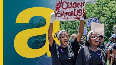 Frauen halten Plakate hoch, während sie an einer Demonstration in Südafrika teilnehmen.