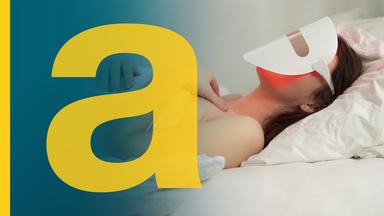 Eine Frau liegt im Bett und trägt dabei eine Maske zur LED-Lichttherapie