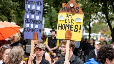 Menschen nehmen an einer Demonstration des Bündnisses gegen Verdrängung und hohe Mieten unter dem Motto «Her mit den Wohnungen! Runter mit den Mieten!» mit einem Schild mit der Aufschrift