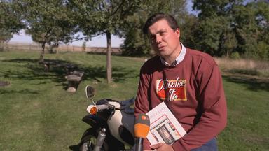 "Ostfluencer" und Pfarrer Justus Geilhufe lehnt an einem Motorrad und wird interviewt