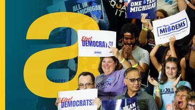 Anhänger der Demokratischen Partei auf einer Tribüne mit "Elect Democrats"-Plakaten.