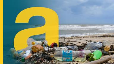 Eine Frau geht an einem Strand spazieren, an dem Plastikmüll angespült wurde
