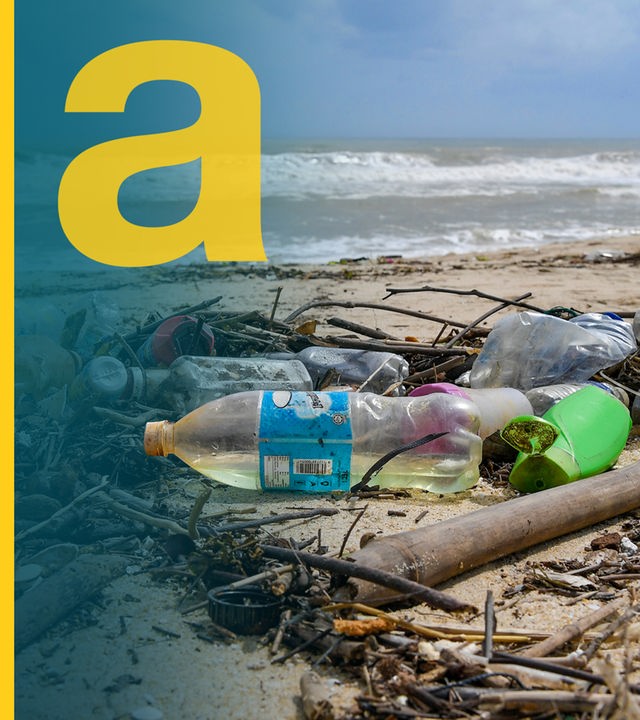 Eine Frau geht an einem Strand spazieren, an dem Plastikmüll angespült wurde