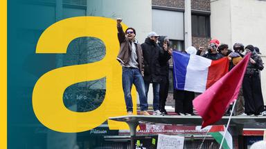 Demonstrierende in Paris schwenken eine Trikolore.