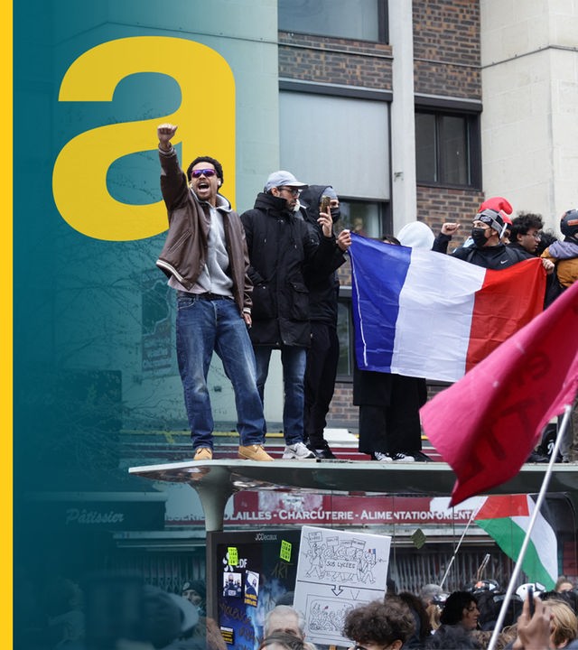 Demonstrierende in Paris schwenken eine Trikolore.