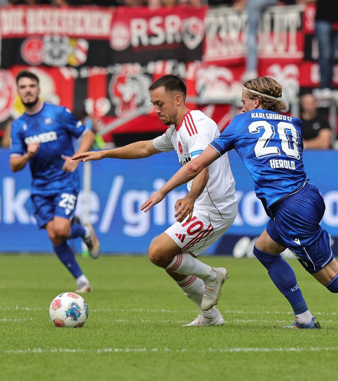Nürnbergs Julian Justvan und David Herold vom Karlsruher SC kämpfen um den Ball.