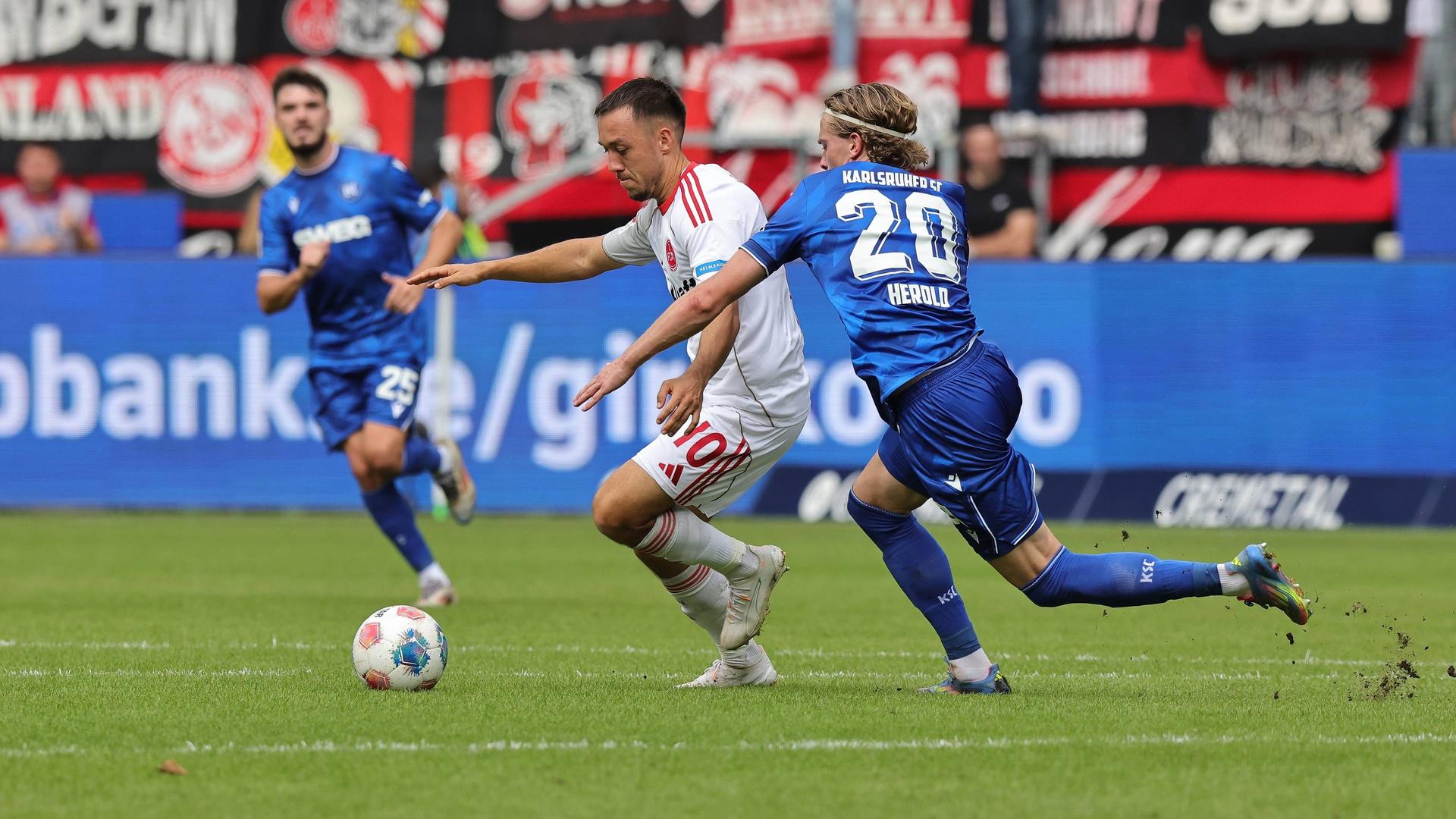 Nürnbergs Julian Justvan und David Herold vom Karlsruher SC kämpfen um den Ball.