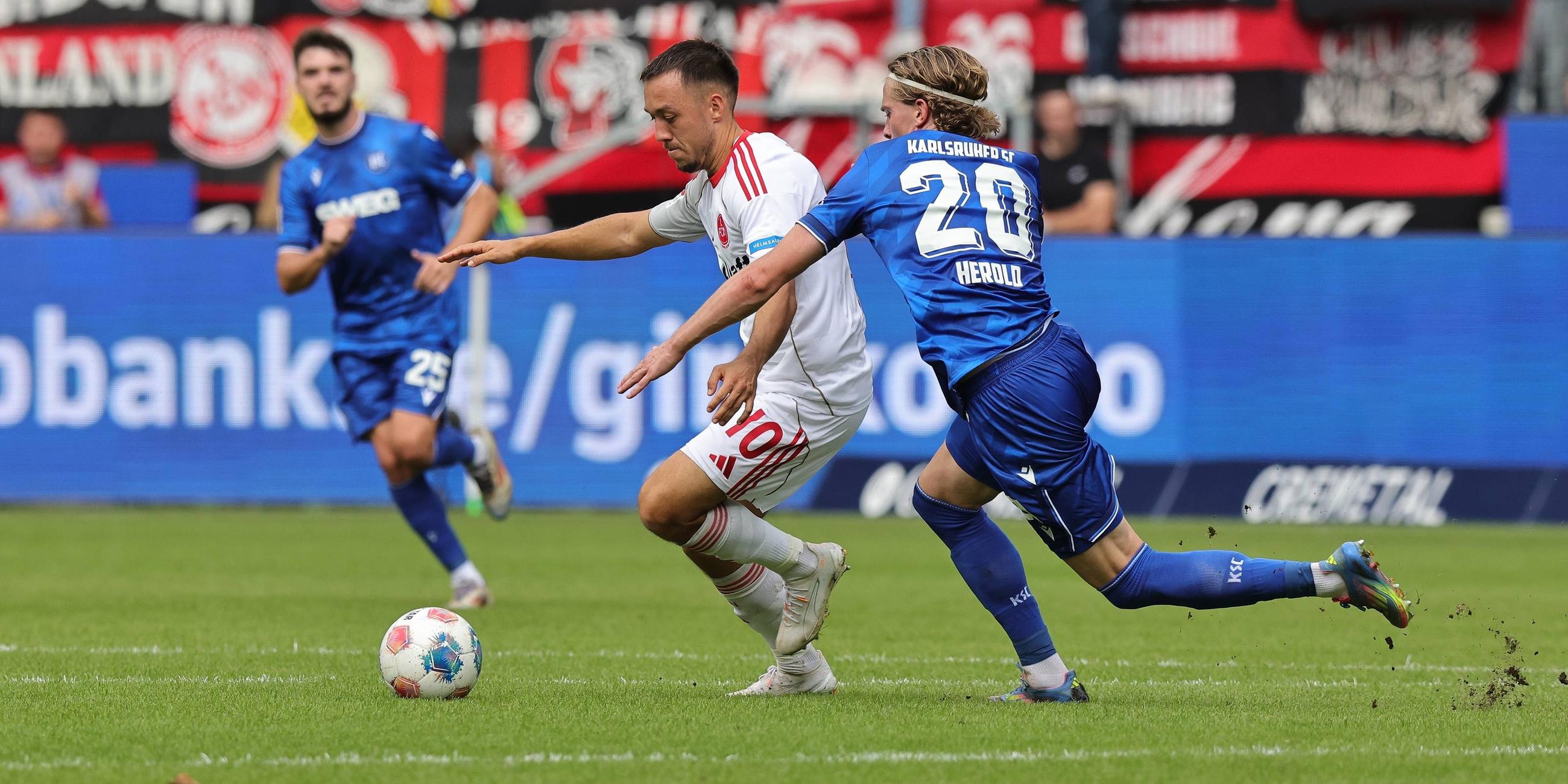 Nürnbergs Julian Justvan und David Herold vom Karlsruher SC kämpfen um den Ball.