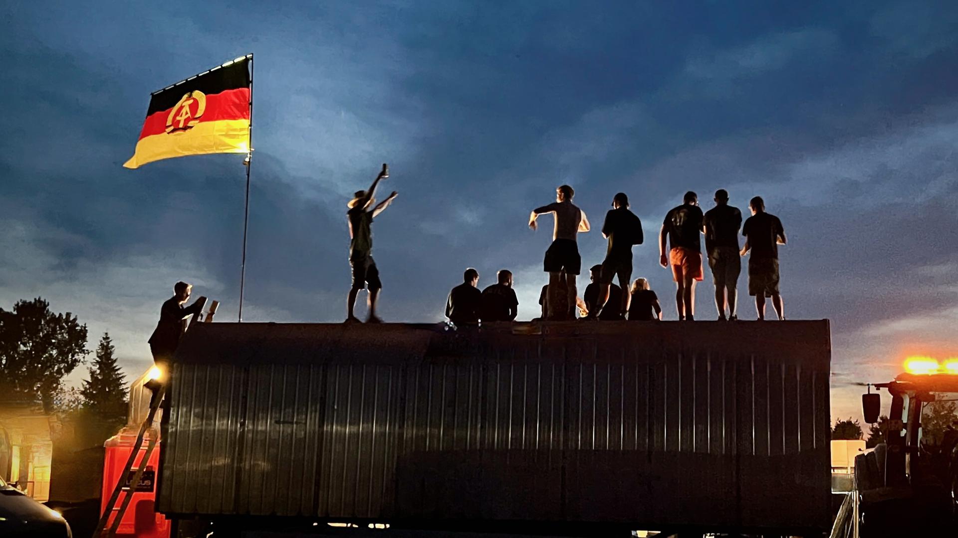 Simsonfans feiern neben den Kultmopeds ihre Ost-Identität unter der DDR-Fahne in Zwickau.