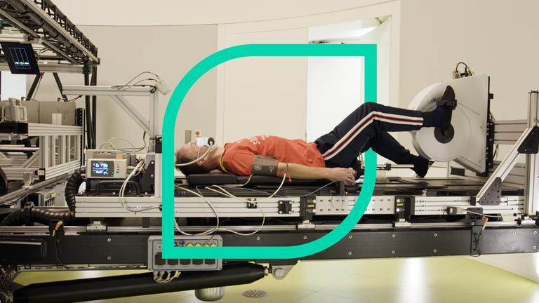 Ein Mann liegt auf einer Trage und tritt in Pedale