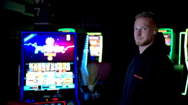 Tom steht neben Spielautomaten und schaut in die Kamera