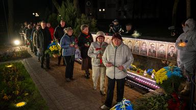 Menschen legen Blumen zu einem Gedenkgottesdienst für die Feuerwehrleute und Arbeiter nieder.
